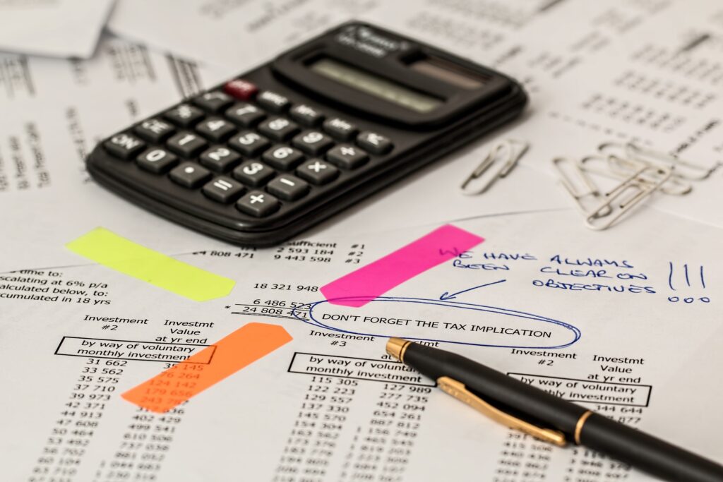 bureau avec une calculatrice, des feuilles mentionnant des investissements financiers