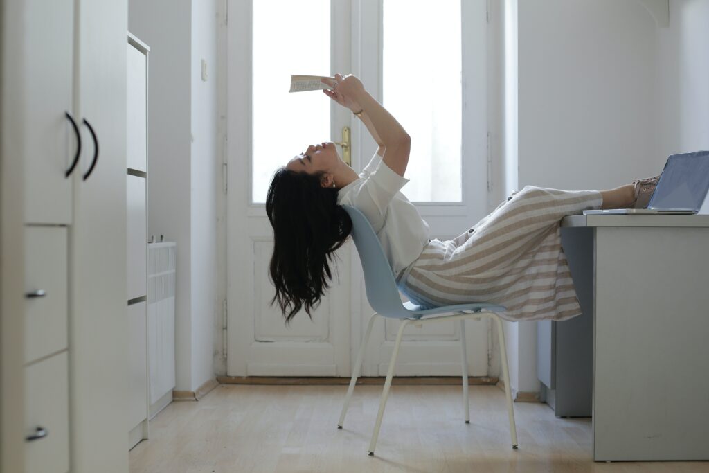 jeune fille sur sa chaise, en train de lire un livre
