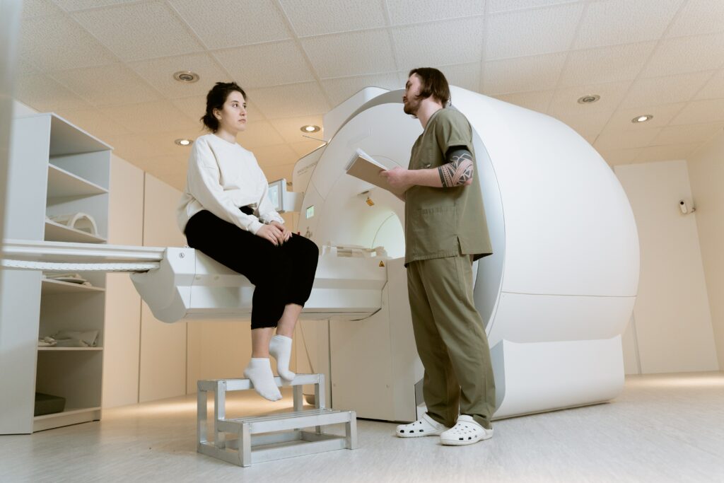 Personnel médical qui discute avec une patiente devant la machine à IRM