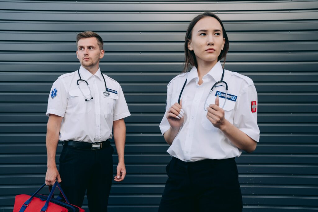 ambulancier homme et femme debout avec leur matériel