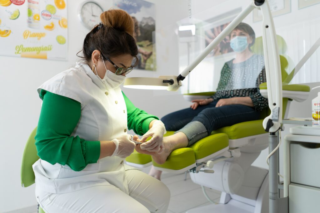pédicure-podologue qui s'occupe des pieds d'une patiente allongée